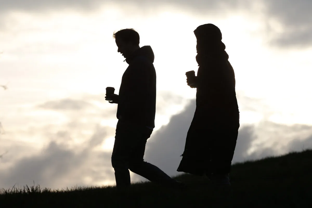 People walk with drinks as they do their daily exercise at Primrose Hill in London on Jan. 15, 2021. (Hollie Adams/Getty Images)