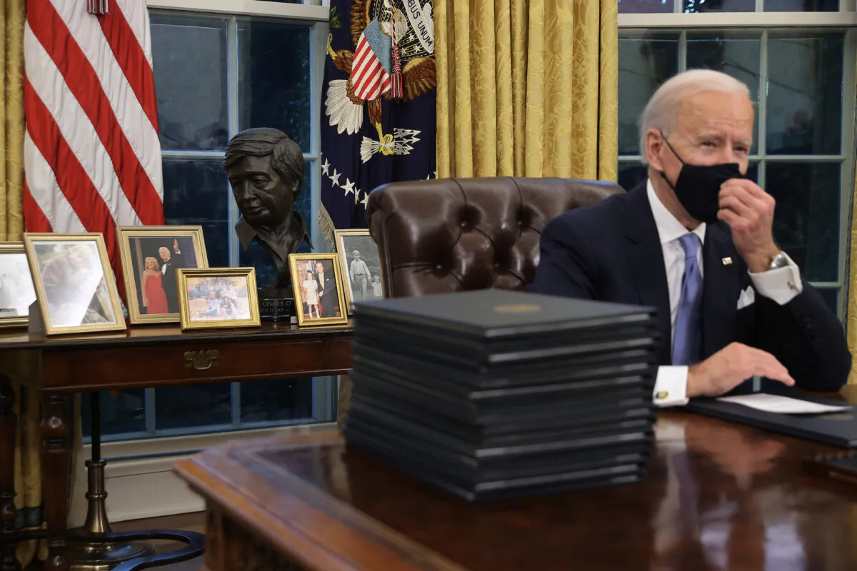 President Joe Biden prepares to sign a series of executive orders at the Resolute Desk in the Oval Office in Washington, on Jan. 20, 2021. (Chip Somodevilla/Getty Images)