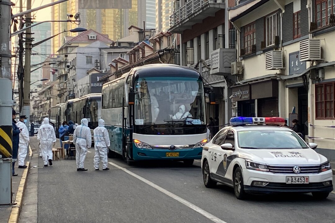 Police and workers arrange buses to remove all residents at a neighborhood in Huangpu district to quarantine centers, in Shanghai on Jan. 21, 2021. (AFP via Getty Images)