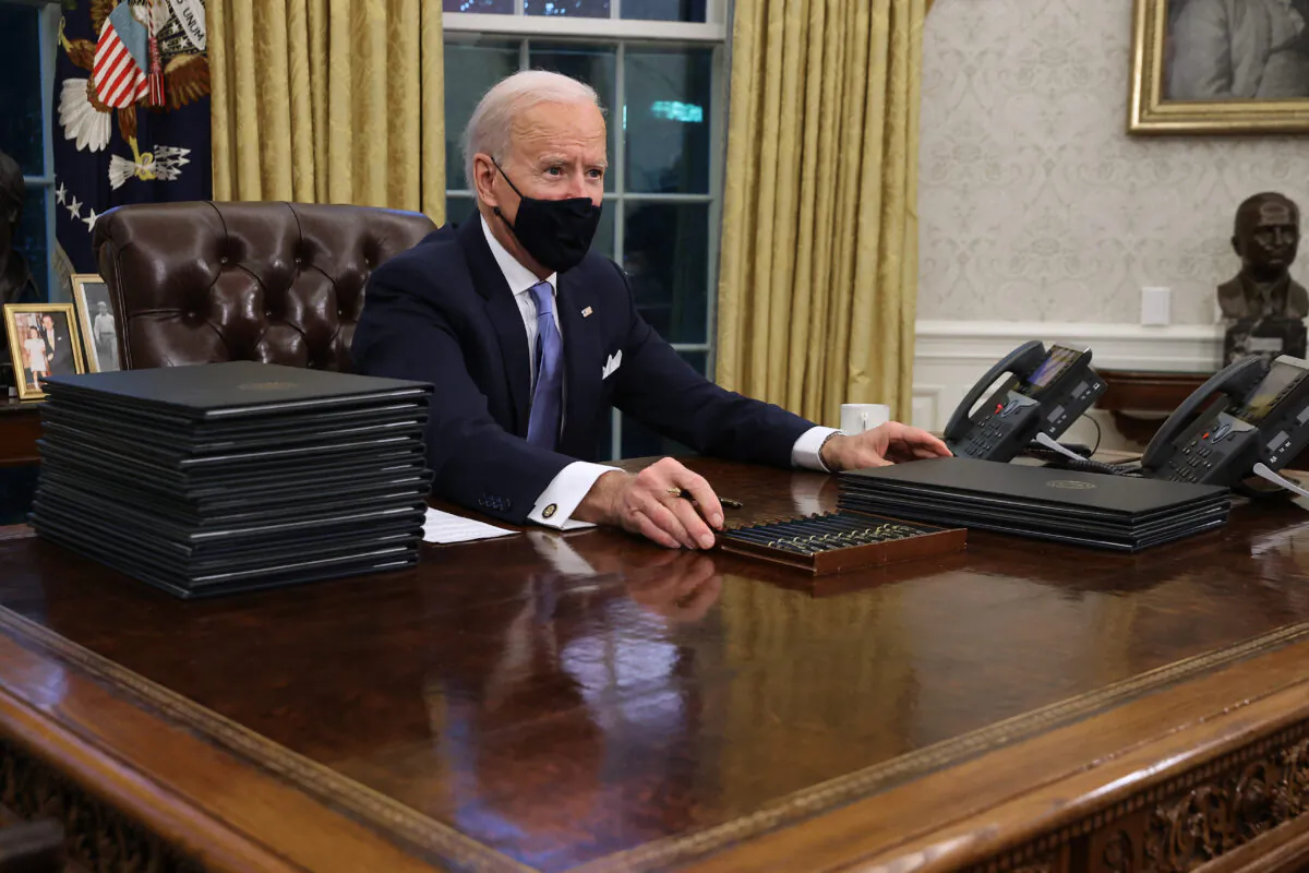 President Joe Biden prepares to sign a series of executive orders at the Resolute Desk in the Oval Office in Washington just hours after his inauguration on Jan. 20, 2021. (Chip Somodevilla/Getty Images)