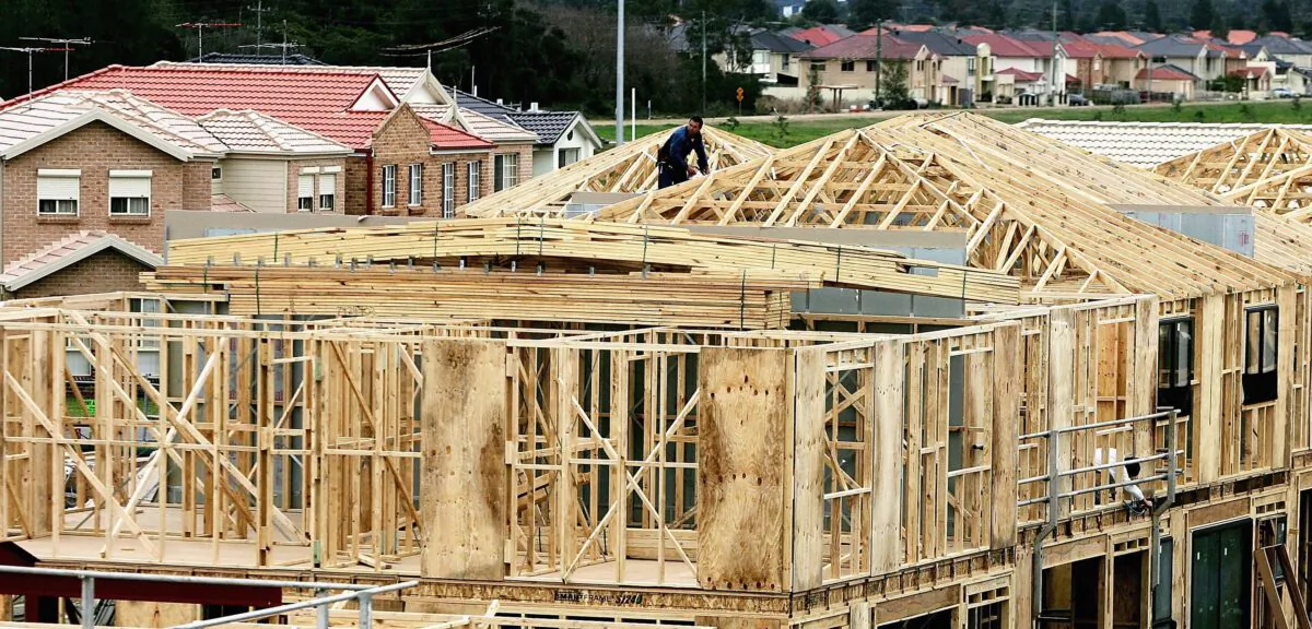 A builder works on a house under construction amongst an established suburb August 2, 2006 in Sydney, Australia. (Ian Waldie/Getty Images)