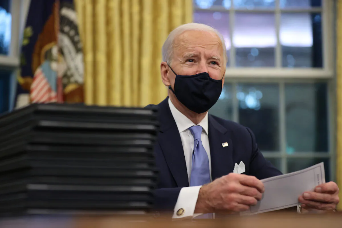 President Joe Biden prepares to sign a series of executive orders at the Resolute Desk in the Oval Office just hours after his inauguration in Washington on Jan. 20, 2021. (Chip Somodevilla/Getty Images)