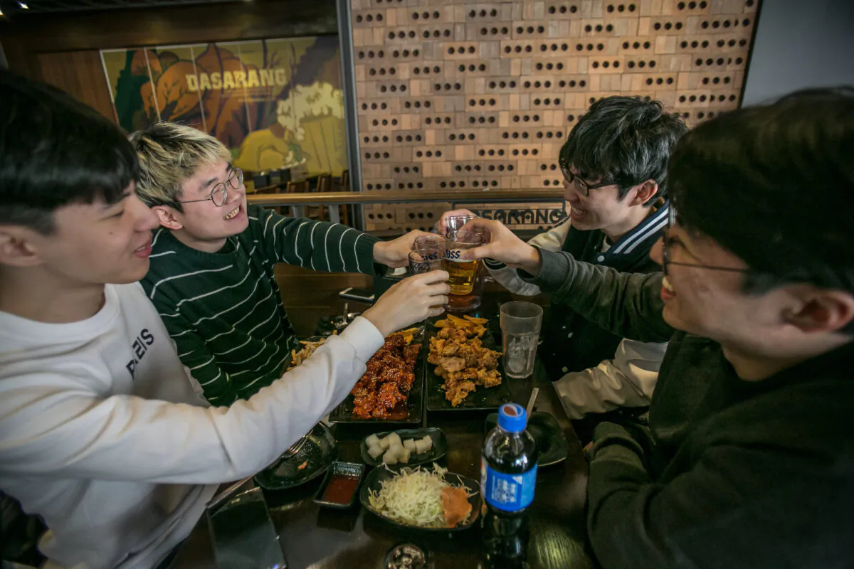 Young South Koreans drink beer and eat deep-fried chicken dishes at a restaurant in Seoul, South Korea on March 10, 2017. (Jean Chung/Getty Images)