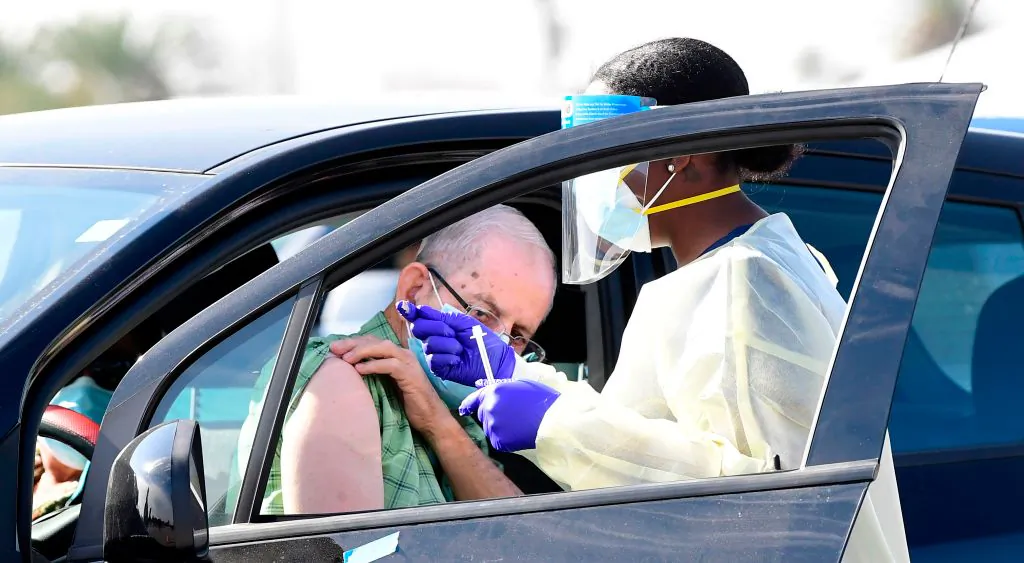 People pull up in their vehicles for COVID-19 vaccines in the parking lot of The Forum in Inglewood, Calif., on Jan. 19, 2021. (Frederic J. BROWN/AFP via Getty Images)