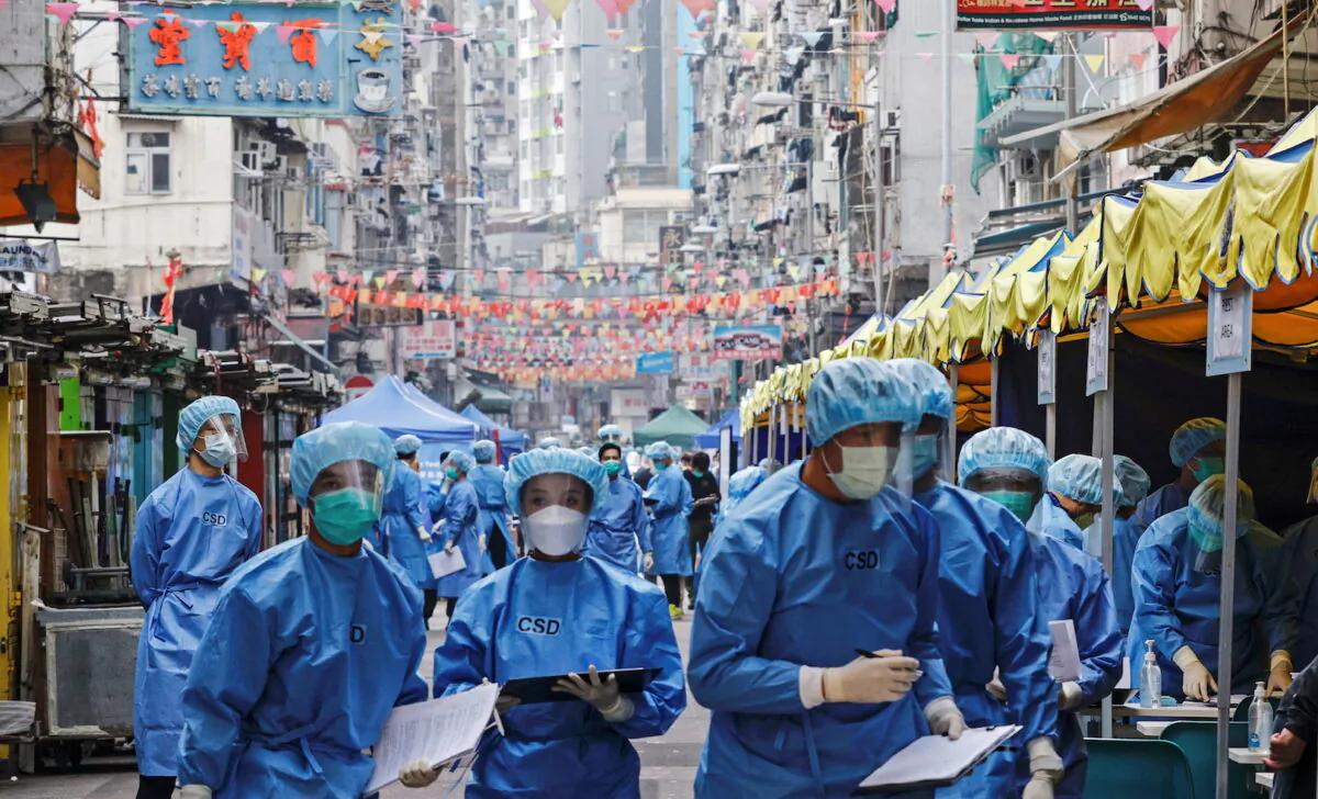 Health workers are seen in protective gear inside a locked down portion of the Jordan residential area to contain a new outbreak of COVID-19 in Hong Kong on Jan. 23, 2021. (Tyrone Siu/Reuters)