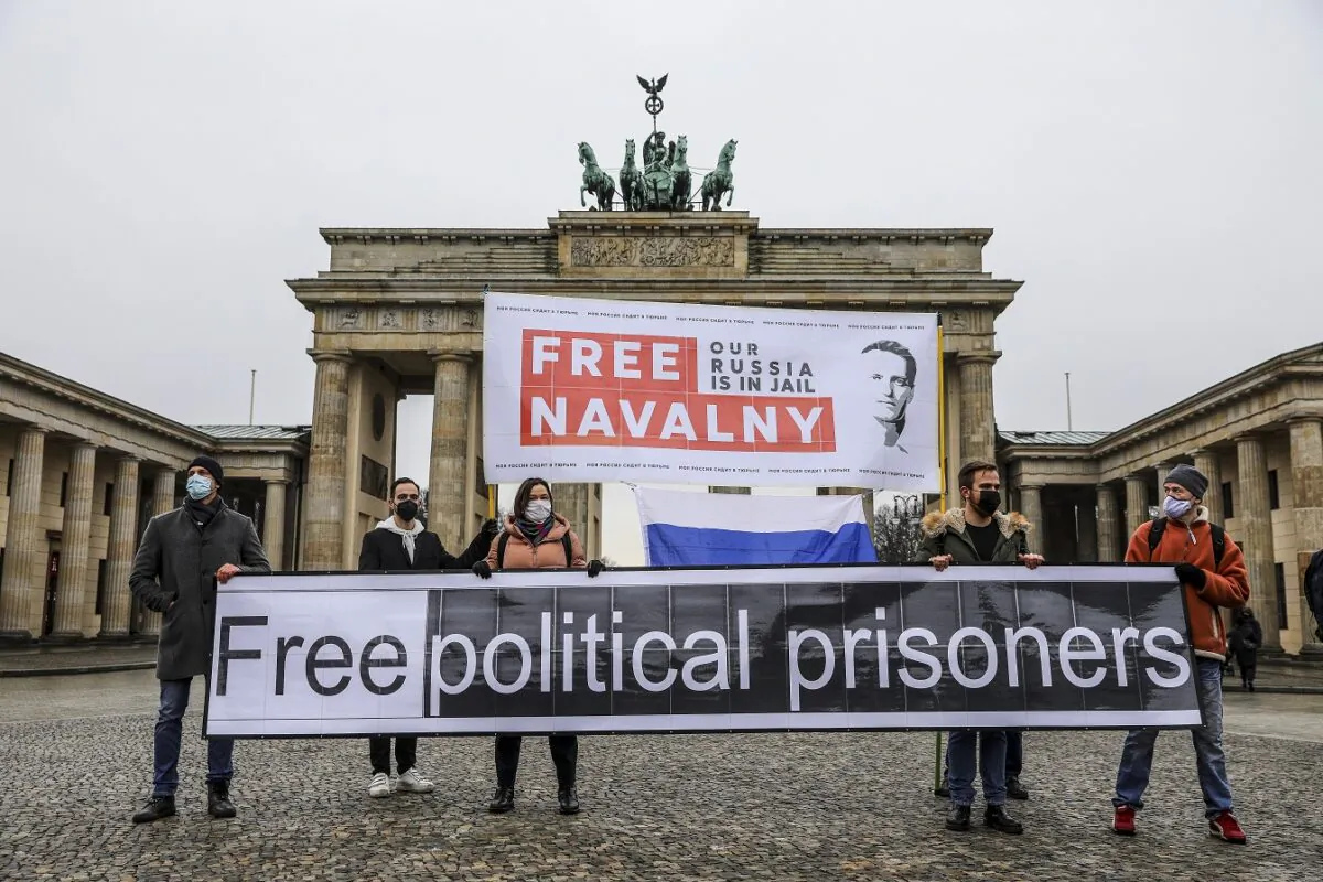 Protesters hold banners reading "FREE NAVALNY" and "FREE POLITICAL PRISONERS" in front of the Brandenburg Gate in Berlin, on Jan. 23, 2021. (Omer Messinger/Getty Images)