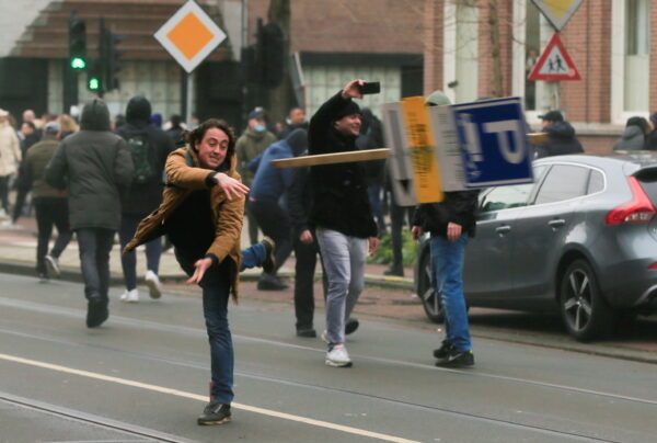 A demonstrator throws a sign