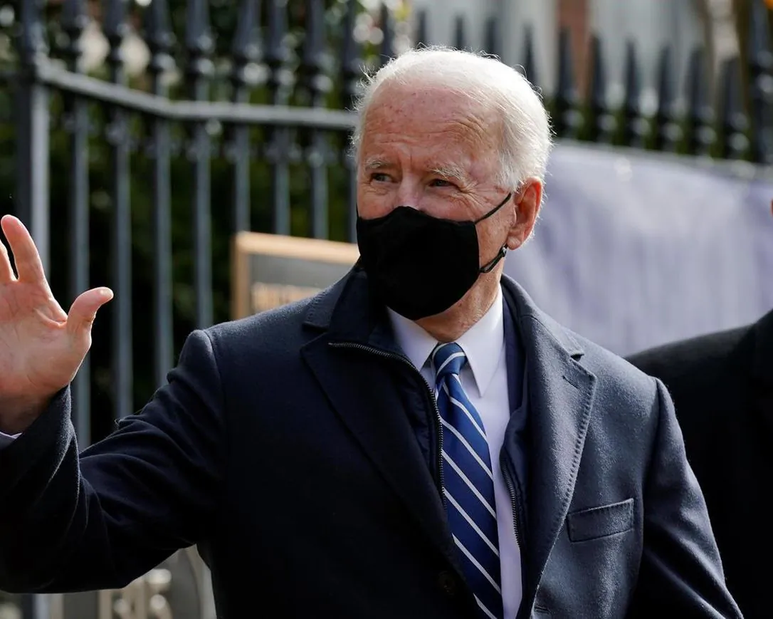 U.S. President Joe Biden waves as he departs after attending Mass at Holy Trinity Catholic Church, on Jan. 24, 2021, in the Georgetown neighbourhood of Washington. (The Canadian Press/Patrick Semansky/AP)