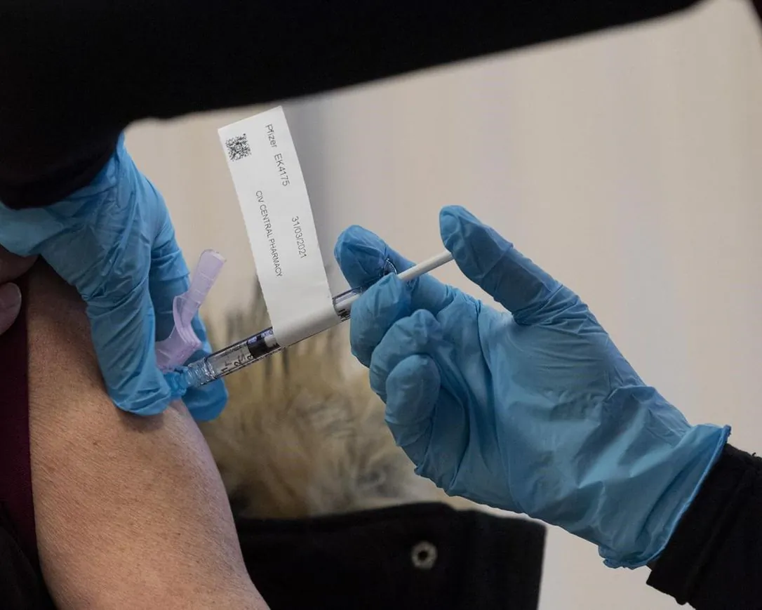 The Pfizer-BioNTech COVID-19 vaccine is administered to a personal support worker at the Ottawa Hospital on December 15, 2020 in Ottawa. (Adrian Wyld/The Canadian Press)