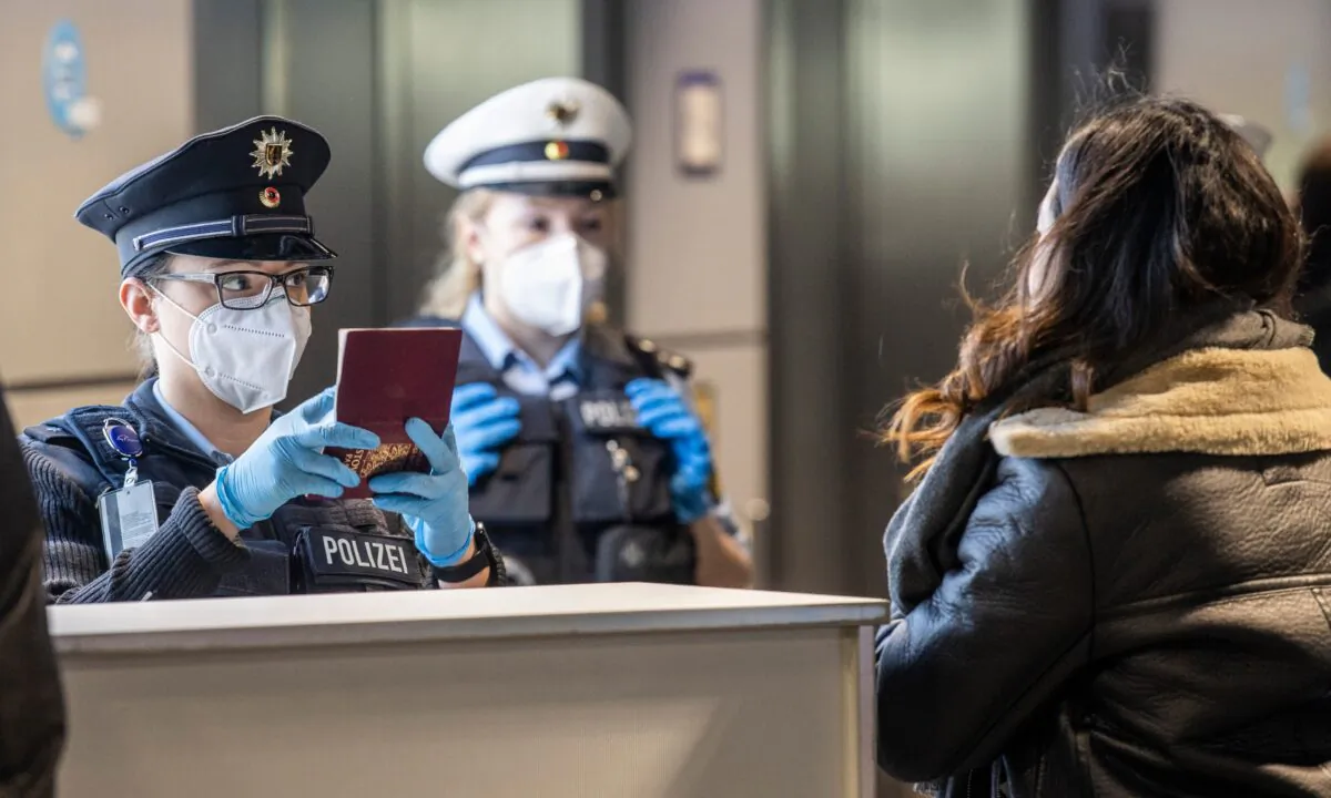 Officers of the German Federal Police check passengers arriving by plane from Prague at the Frankfurt Airport in Frankfurt, Germany, on Jan. 24, 2021. (Boris Roessler/dpa via AP)