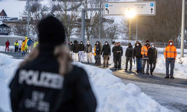 People wait in front of a coronavirus test station