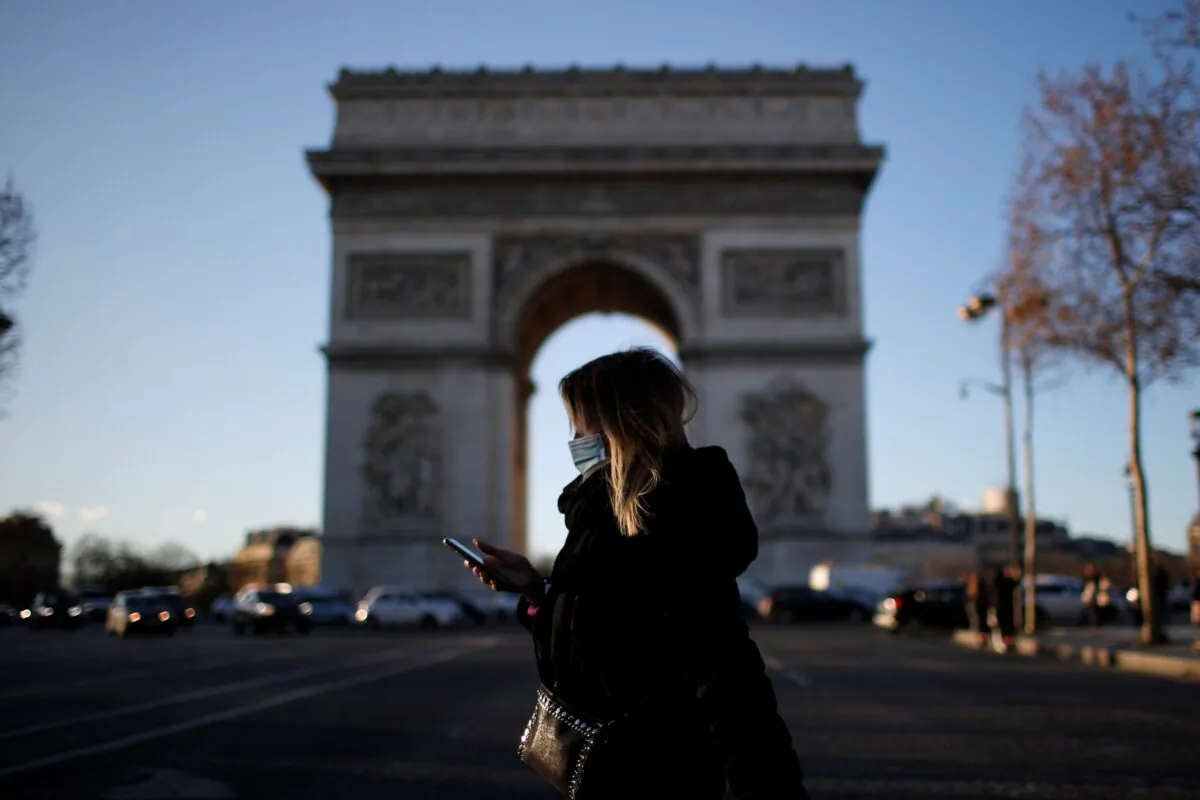 A woman, walks past Champs Elysees Avenue near the Arc de Triomphe in Paris, in France, on Jan. 25, 2021. (Gonzalo Fuentes/Reuters)