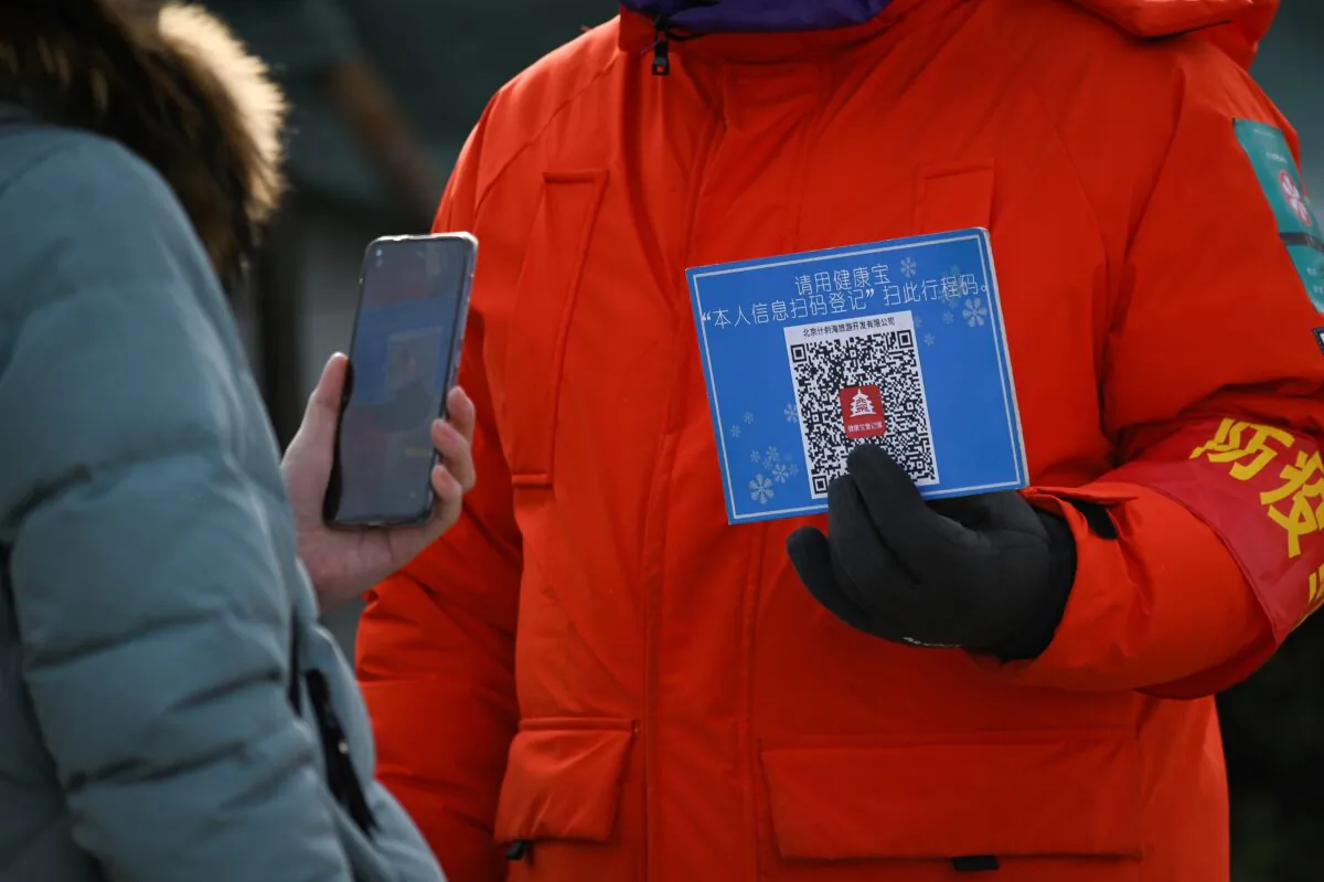 A woman uses her cellphone to scan a venue code for health registration before entering an outdoor ice rink in Beijing, China on Jan. 12, 2021. (Wang Zhao/AFP via Getty Images)