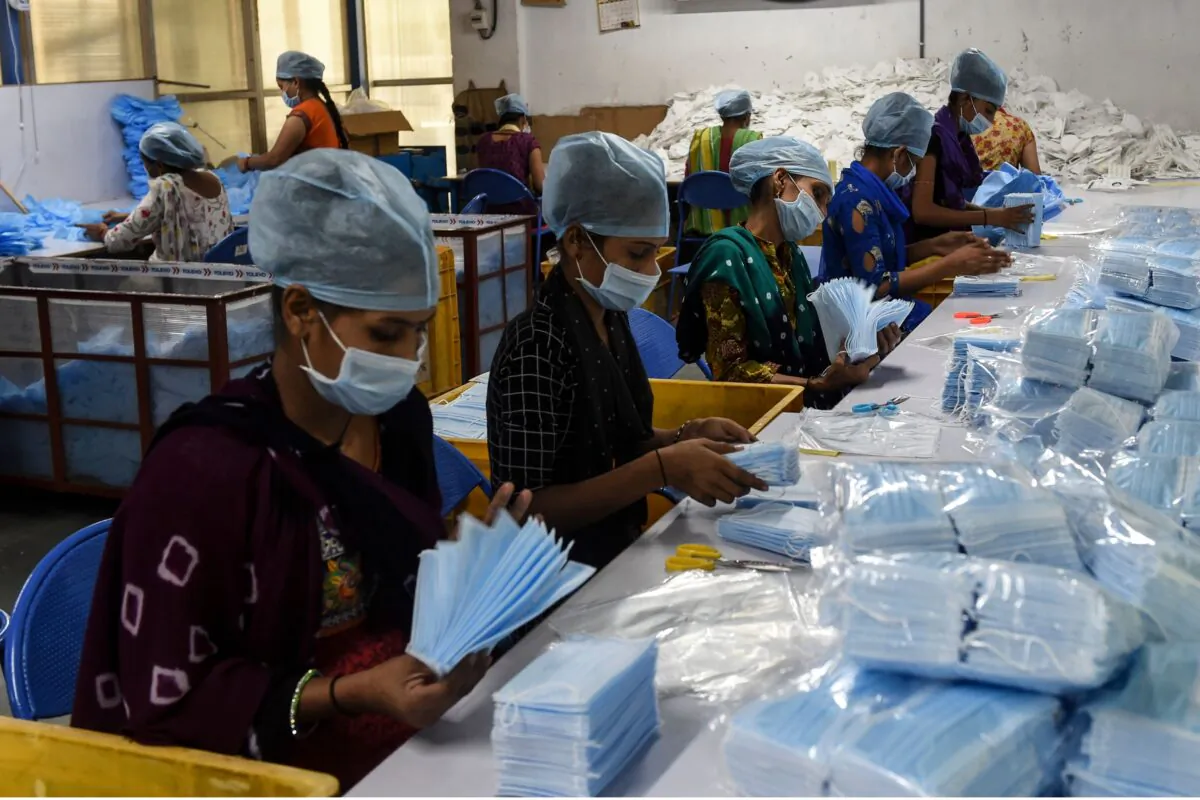 Employees pack surgical facemasks at a factory near Changodar, some 20 kms from Ahmedabad, India, on Nov. 8, 2020. (SAM PANTHAKY/AFP via Getty Images)