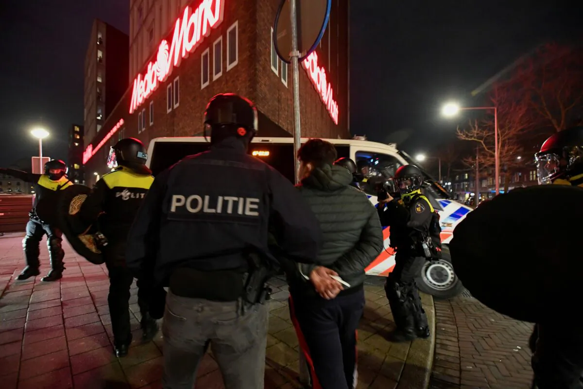 Police officers detain a demonstrator protesting against restrictions put in place to curb the spread of the coronavirus disease (COVID-19) in Rotterdam, Netherlands, Jan. 26, 2021. (Stringer/Reuters)