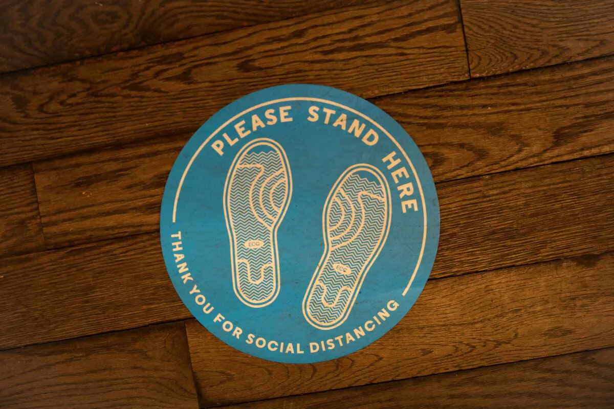 A social distancing sign is displayed on the floor in a store in New York on Jan. 20, 2021. (Chung I Ho/The Epoch Times)