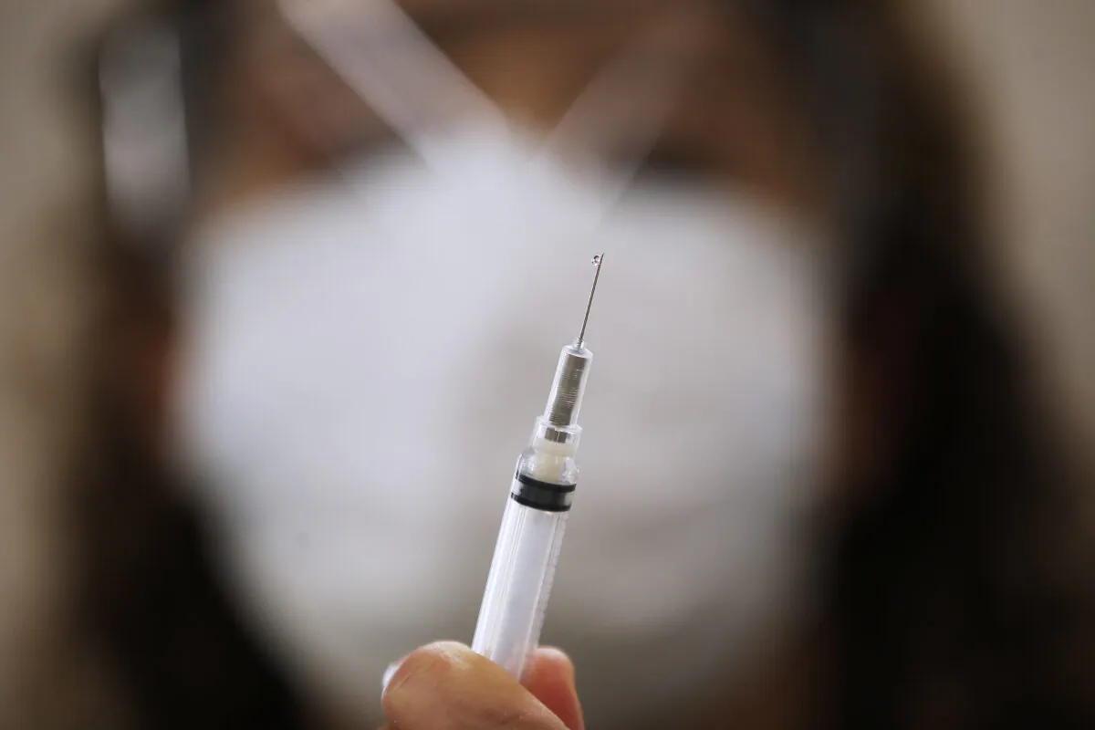 LoriAnn Laramee, public health nurse, prepares dilutant for the COVID-19 vaccine in the COVID-19 vaccination clinic at the Health Sciences Centre in Winnipeg, on Dec. 16, 2020.
(John Woods/The Canadian Press)
