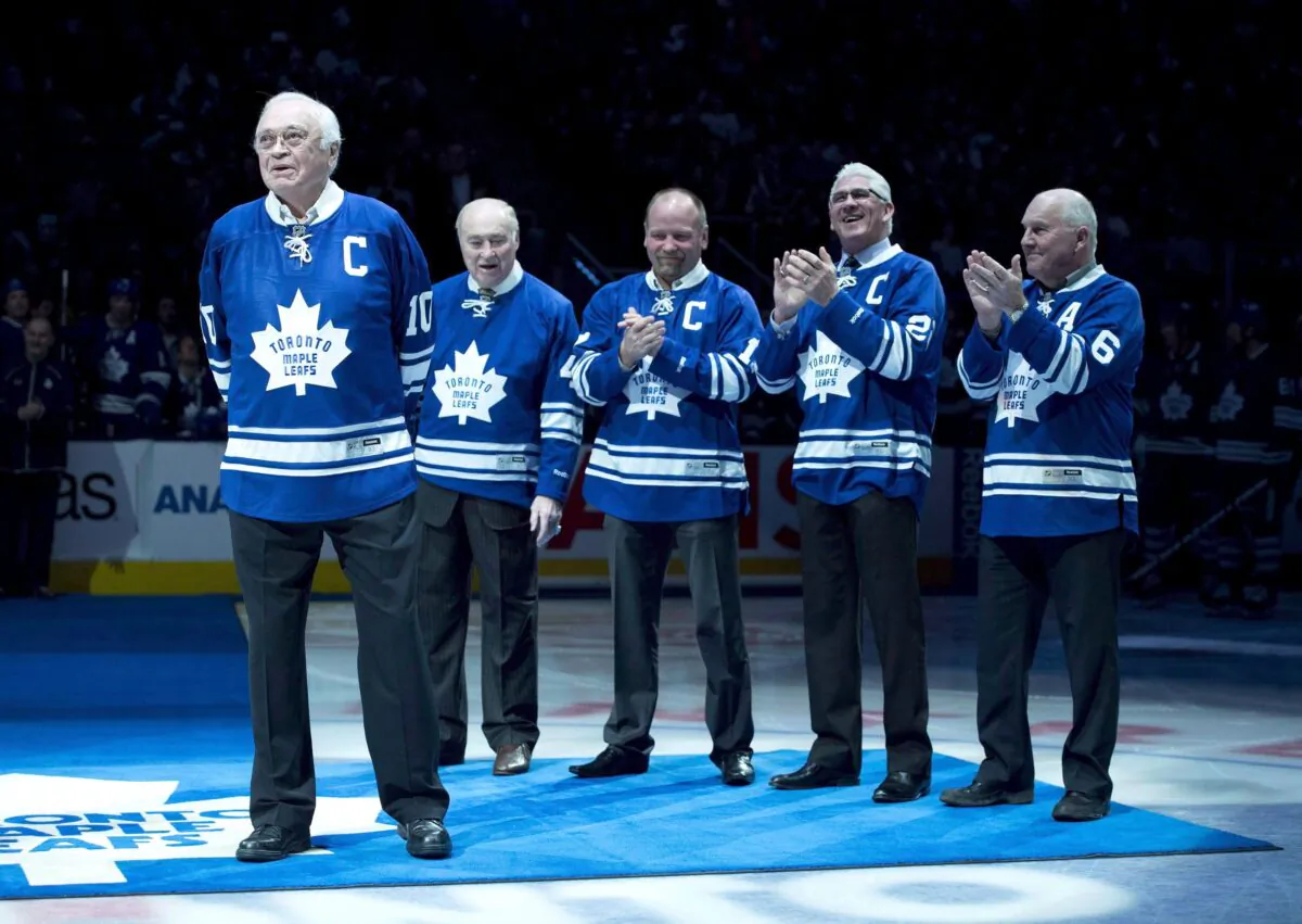Toronto Maple Leafs alumni applaud fellow alumni George Armstrong (L) during a ceremony before the Toronto Maple Leafs and Winnipeg Jets NHL game in Toronto on Feb. 21, 2015. Armstrong died on Jan. 24, 2020. (The Canadian Press/Darren Calabrese)