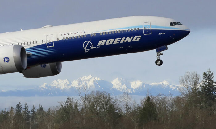 A Boeing 777X airplane takes off on its first flight with the Olympic Mountains in the background at Paine Field in Everett, Wash., on Jan 25, 2020. (Ted S. Warren/AP Photo)