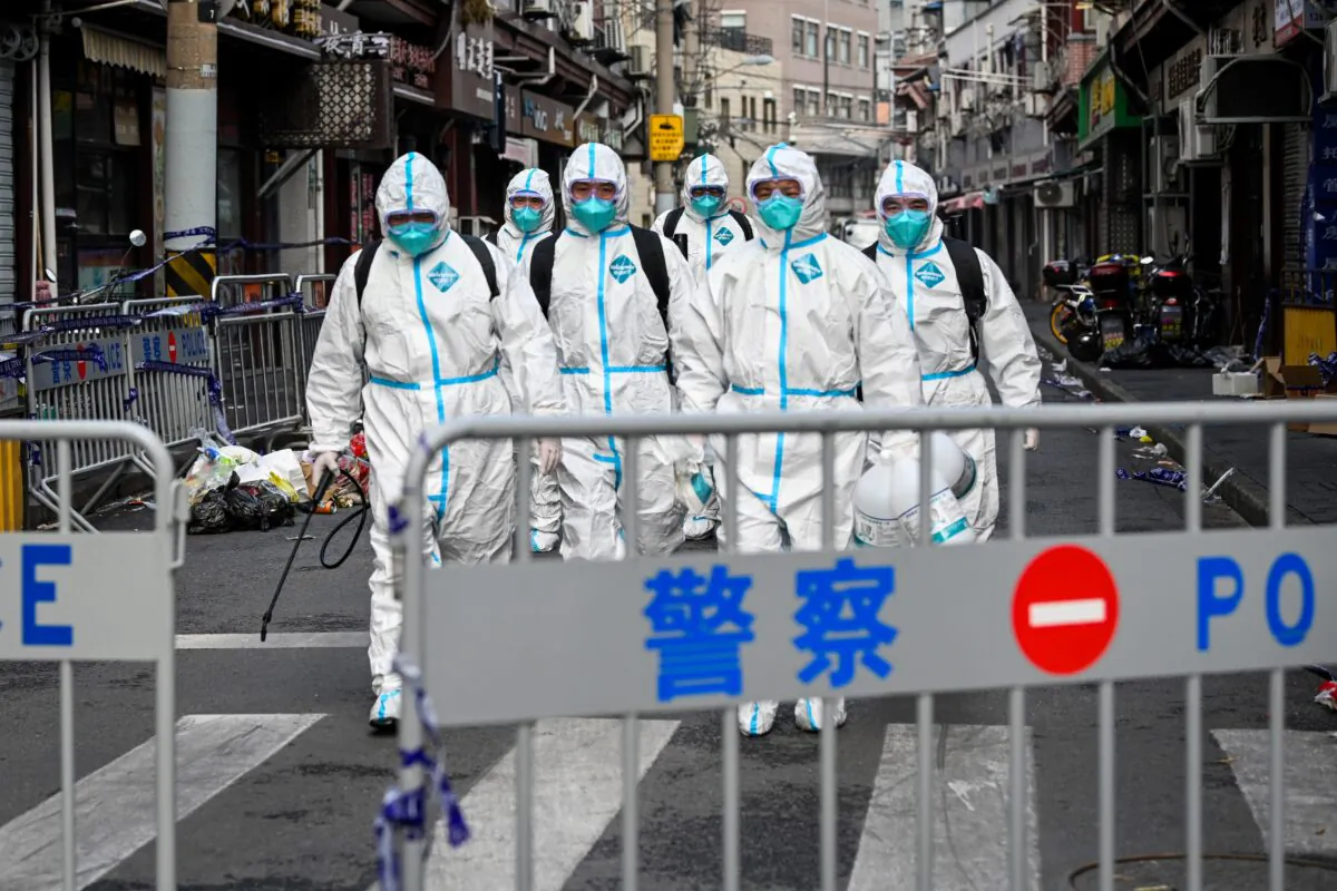 Health workers walk out from a blocked off area after spraying disinfectant in Huangpu district, Shanghai, China, on Jan. 27, 2021. (STR/AFP via Getty Images)