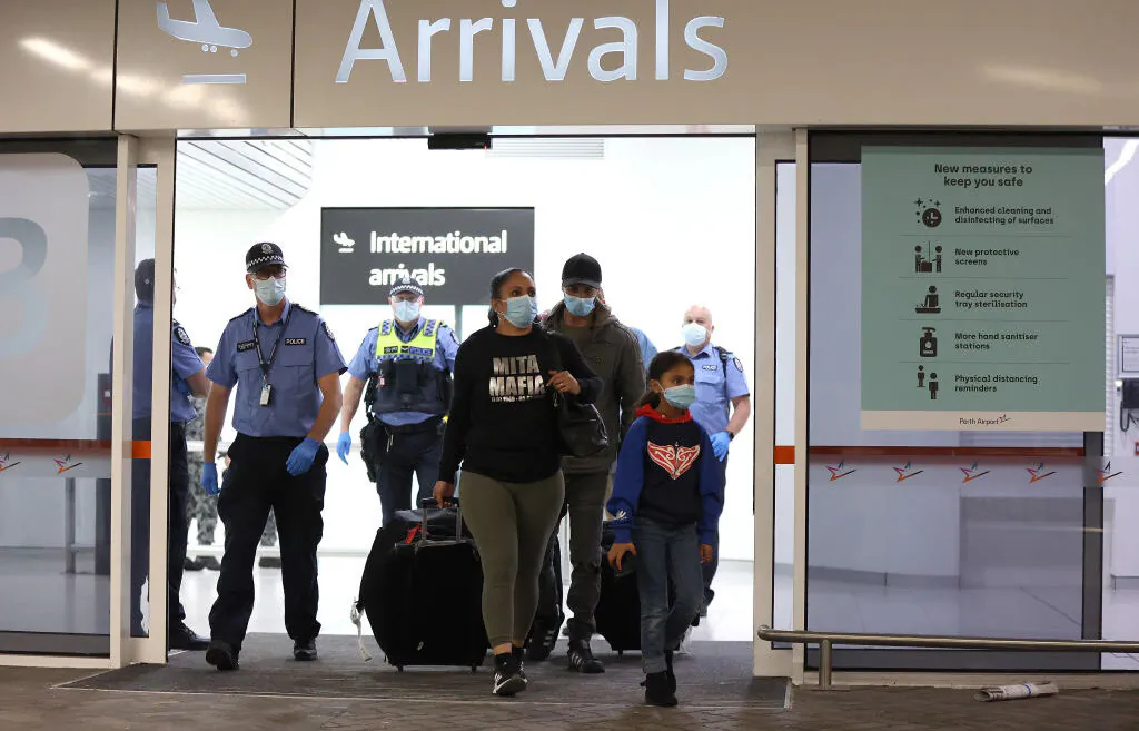 Passengers after being processed following their arrival at Perth Airport, before being driven to a CBD hotel for quarantining in Perth, Australia, on Oct. 19, 2020. (Paul Kane/Getty Images)