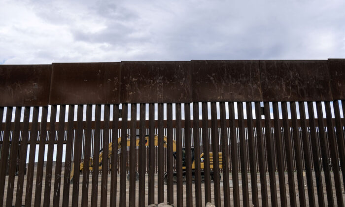 A caterpillar parks between fences at a reinforced section of the U.S.-Mexico border fencing eastern Tijuana, Baja California state, Mexico on Jan. 20, 2021. (Guillermo Arias/AFP via Getty Images)