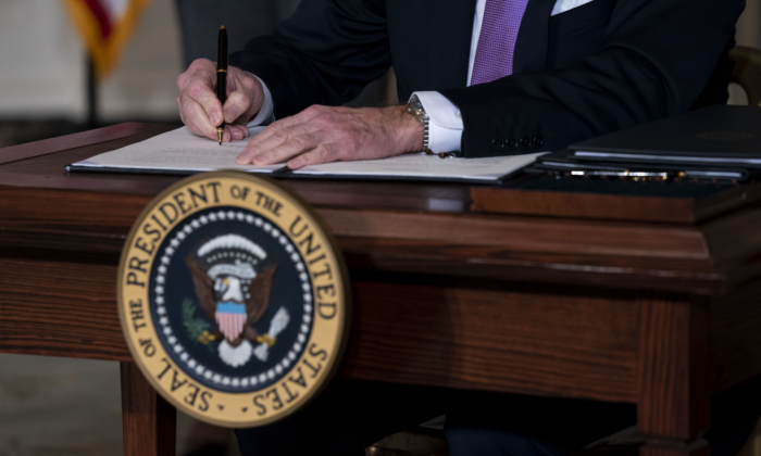 President Joe Biden signs executives orders in the State Dining Room of the White House in Washington on Jan. 26, 2021. (Doug Mills-Pool/Getty Images)