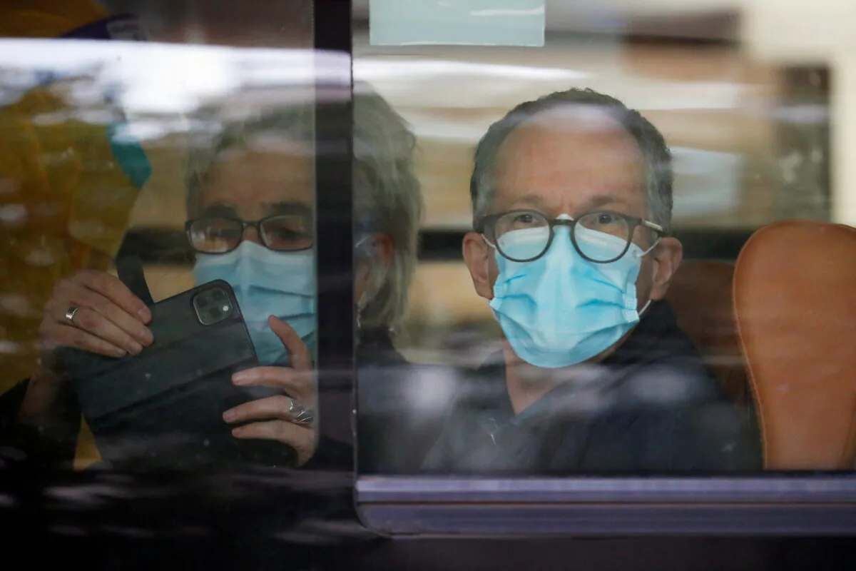 Peter Ben Embarek and Marion Koopmans, members of the World Health Organization (WHO) team tasked with investigating the origins of the coronavirus disease (COVID-19) pandemic, sit on a bus as they leave their quarantine hotel in Wuhan, Hubei province, China, on Jan. 28, 2021. (Reuters/Thomas Peter)