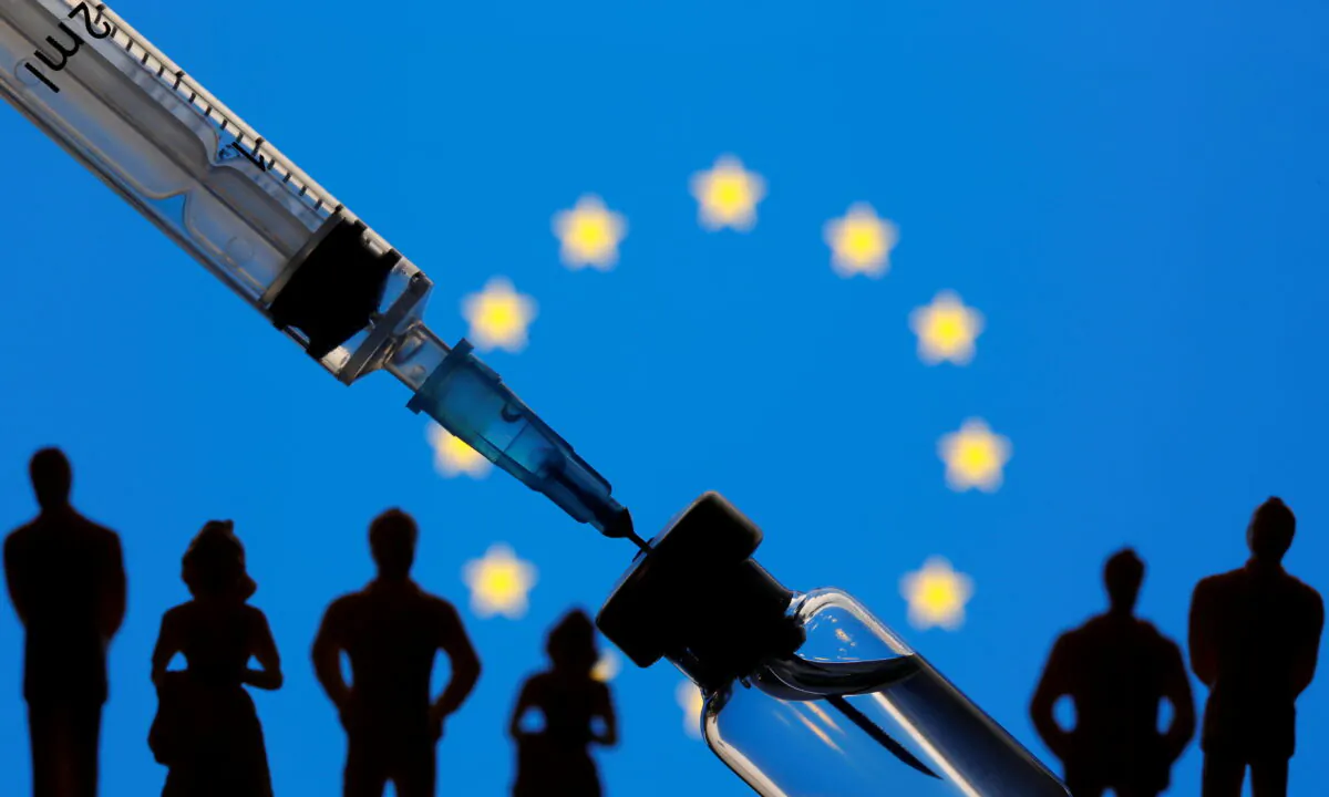 A vial, syringe, and small toy figures are seen in front of a displayed EU flag in this illustration taken Jan. 11, 2021. (Dado Ruvic/Illustration/Reuters)