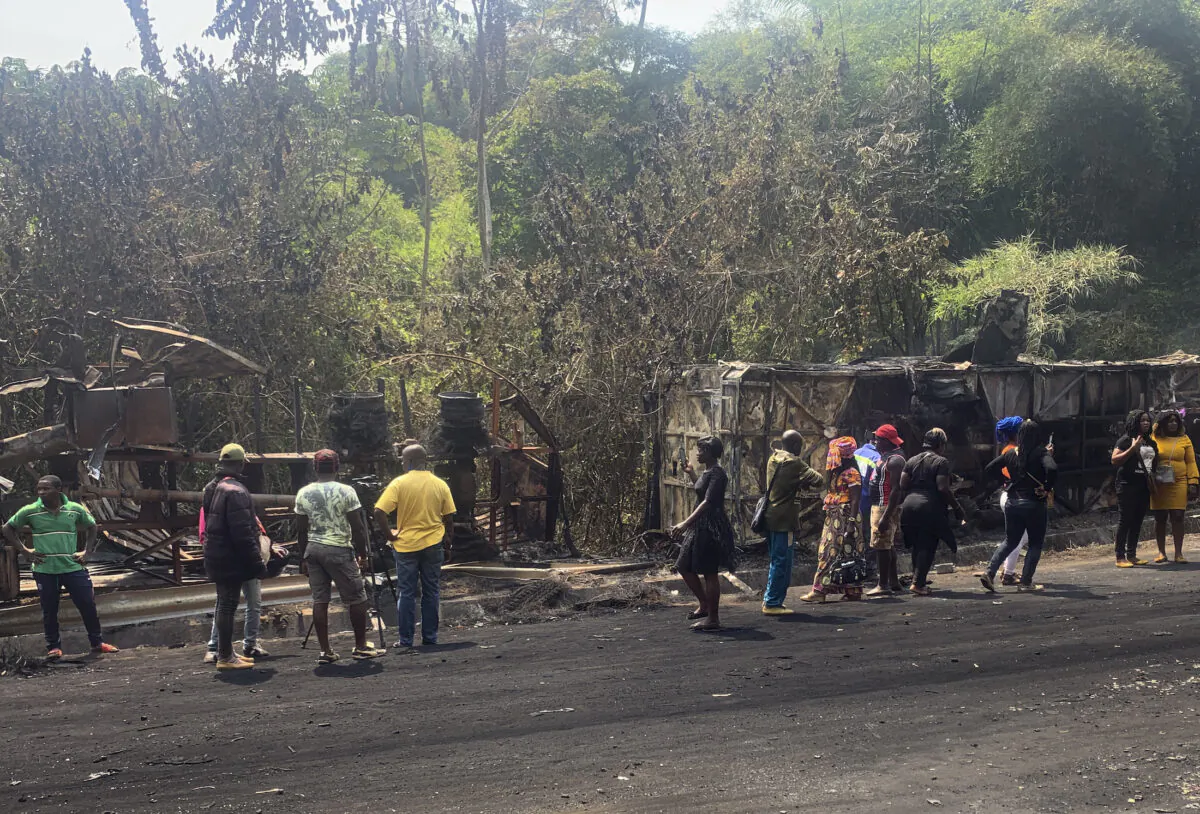 People gather at the scene of a bus crash in Santchou village in western Cameroon on Jan. 27, 2021. (AP Photo)