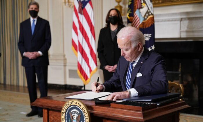 US Vice President Kamala Harris (2-L) and Special Presidential Envoy for Climate John Kerry (L) watch as US President Joe Biden signs executive orders after speaking on tackling climate change, creating jobs, and restoring scientific integrity in the State Dining Room of the White House in Washington, DC on Jan. 27, 2021. ((MANDEL NGAN/AFP via Getty Images)