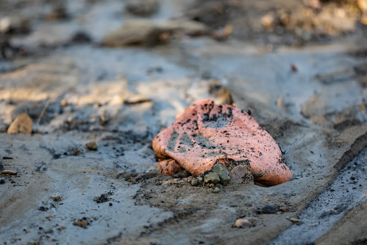 A sandbag moved by heavy water and rain sits covered with dirt in Williams Canyon, Calif., on Jan. 28, 2021. (John Fredricks/The Epoch Times)