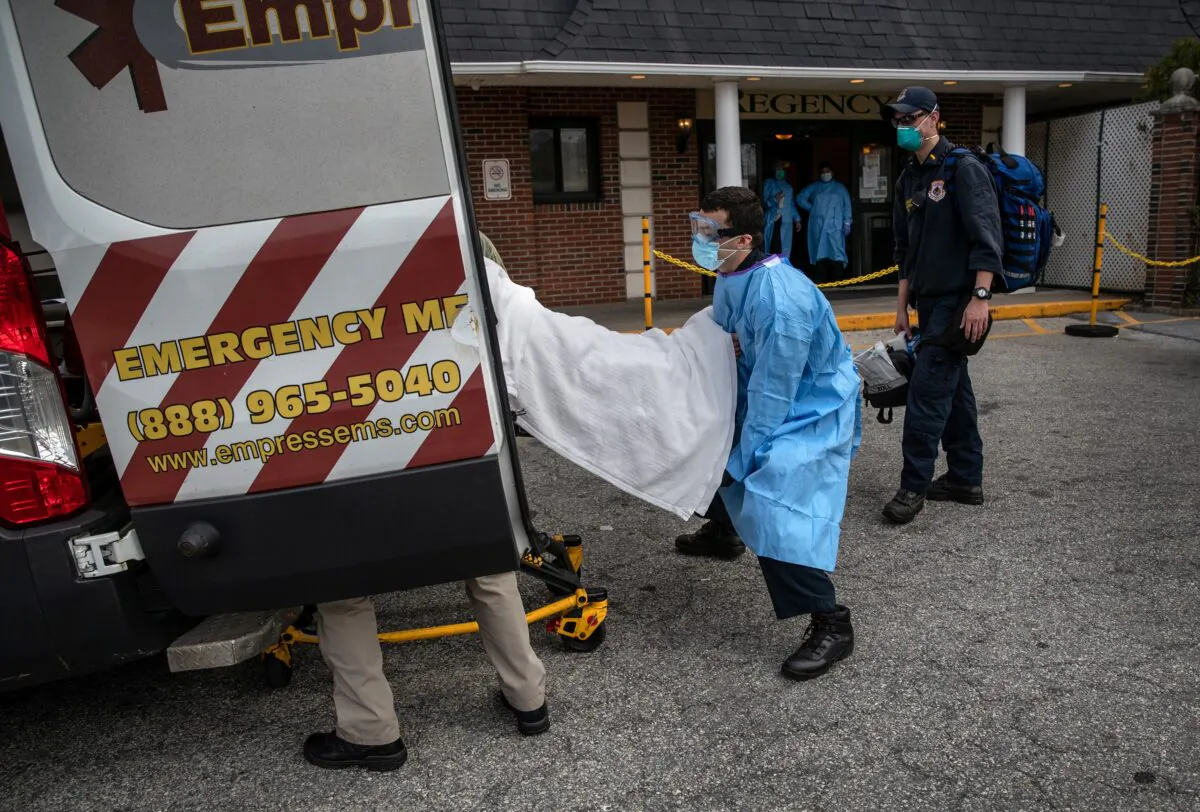 A medic from Empress EMS loads a suspected COVID-19 patient from the Regency Extended Care Center into an ambulance in Yonkers, N.Y., on April 7, 2020. (John Moore/Getty Images)