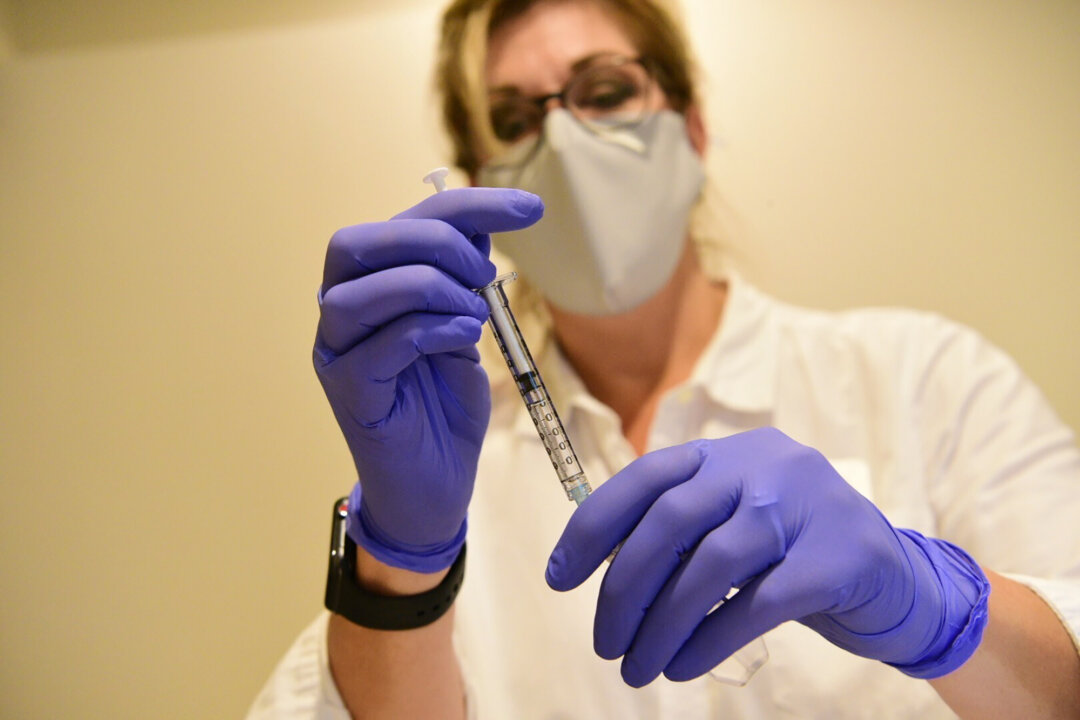 A clinician prepares to administer investigational Janssen COVID-19 vaccine in September 2020. (Johnson & Johnson via AP)