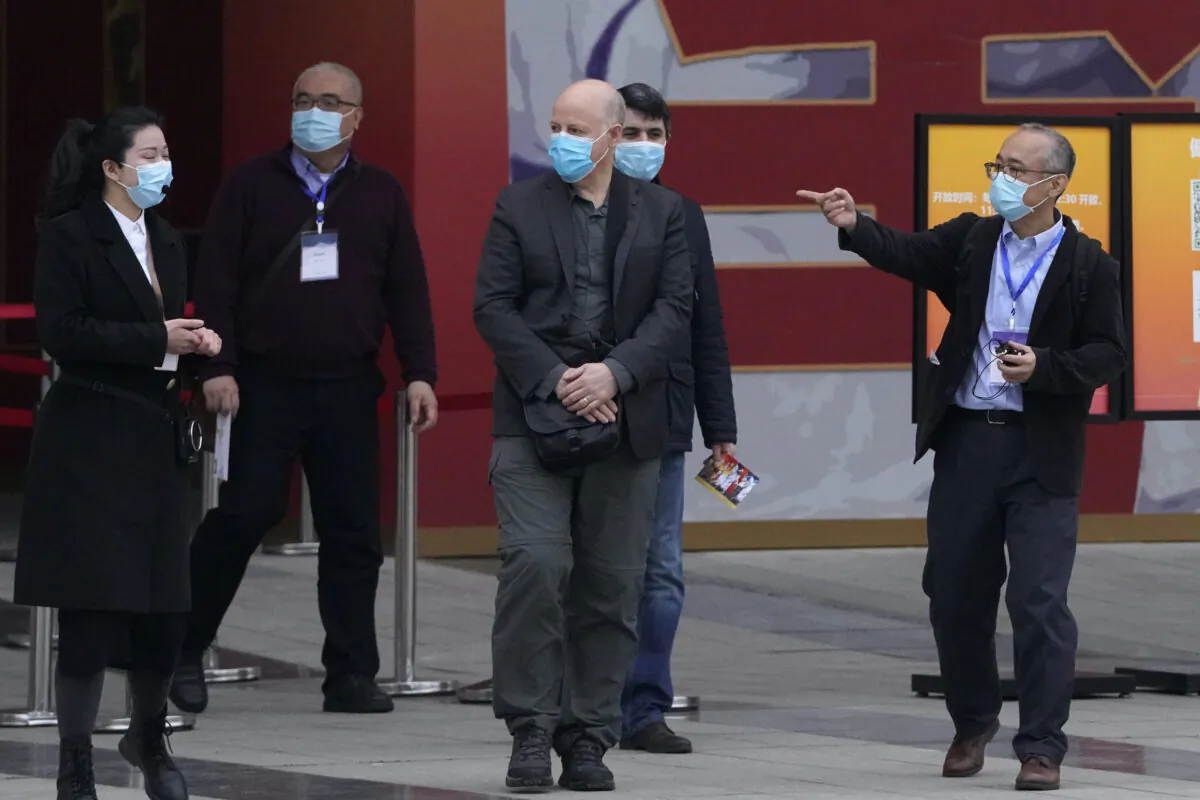Members of the World Health Organization team including Ken Maeda (R), Peter Daszak (third from left), and Vladmir Dedkov (fourth from left) leave after attending an exhibition about the fight against the coronavirus in Wuhan in central China's Hubei province on Jan. 30, 2021. (Ng Han Guan/AP)