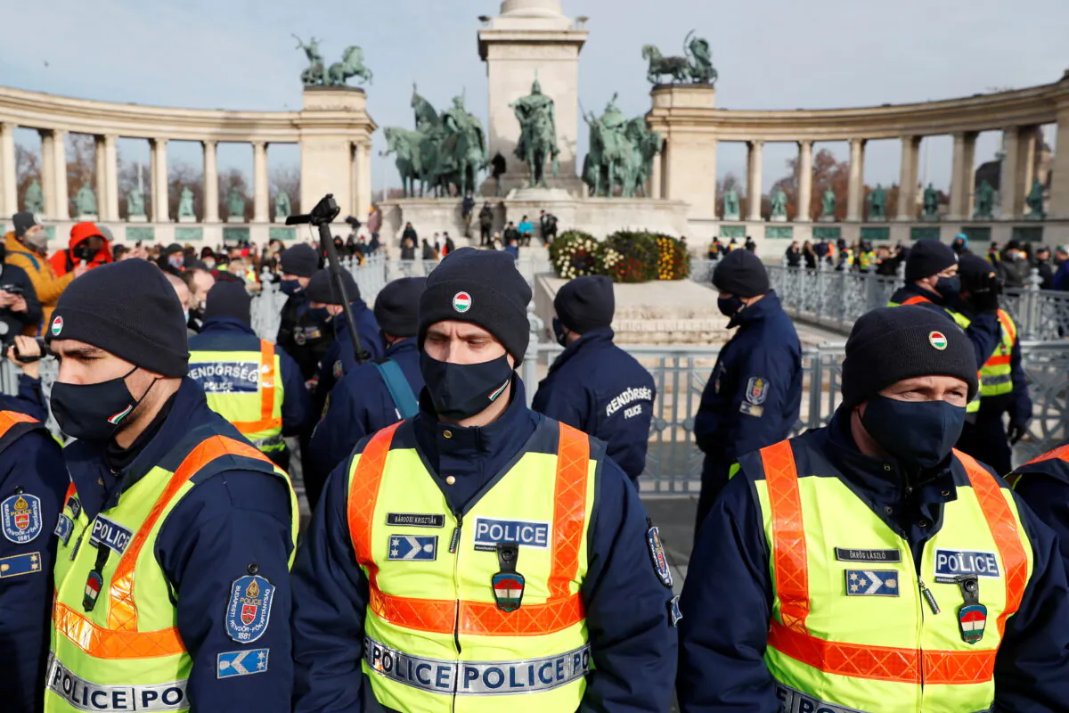 Police officers stand during a demonstration against the coronavirus disease (COVID-19) measures and their economic consequences at Heroes' Square in Budapest, Hungary, on Jan. 31, 2021. (Bernadett Szabo/Reuters)