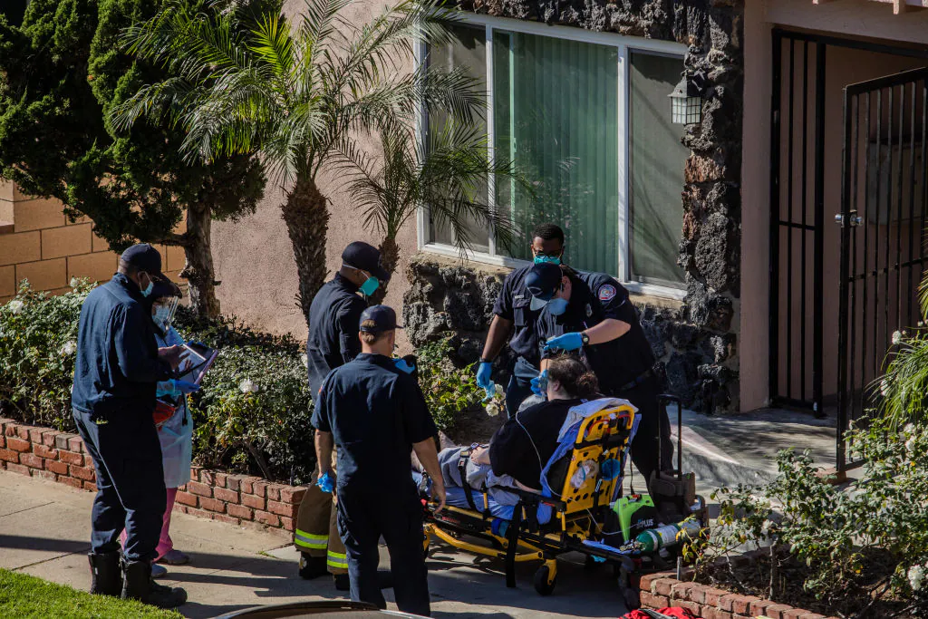 County of Los Angeles paramedics administer oxygen to a potential COVID-19 patient on the sidewalk in front his building before taking him to a hospital in Hawthorne, Calif., on Jan. 21, 2021. (Apu Gomes/Getty Images)
