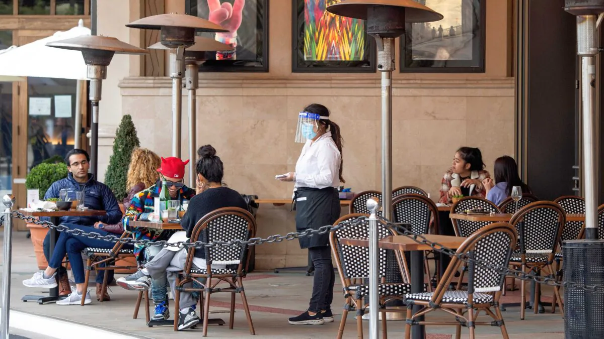 A waitress takes customers' orders in the outdoor seating area of a restaurant in Los Angeles, Calif., on Jan. 28, 2021. (Valerie Macon/AFP via Getty Images)