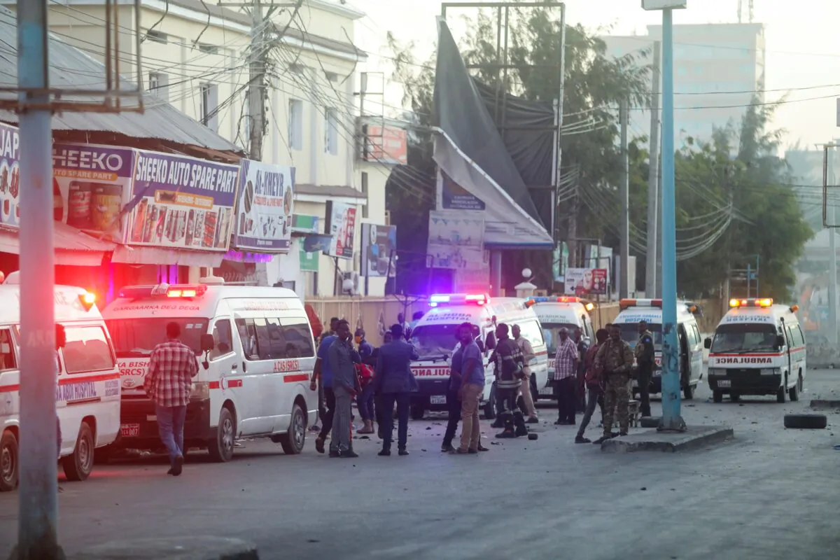 Somali security officers secure the site of a car bomb explosion as paramedics await to rescue the injured in the Kilometre 4 area of Mogadishu, in Somalia, on Jan. 31, 2021. (Feisal Omar/Reuters)