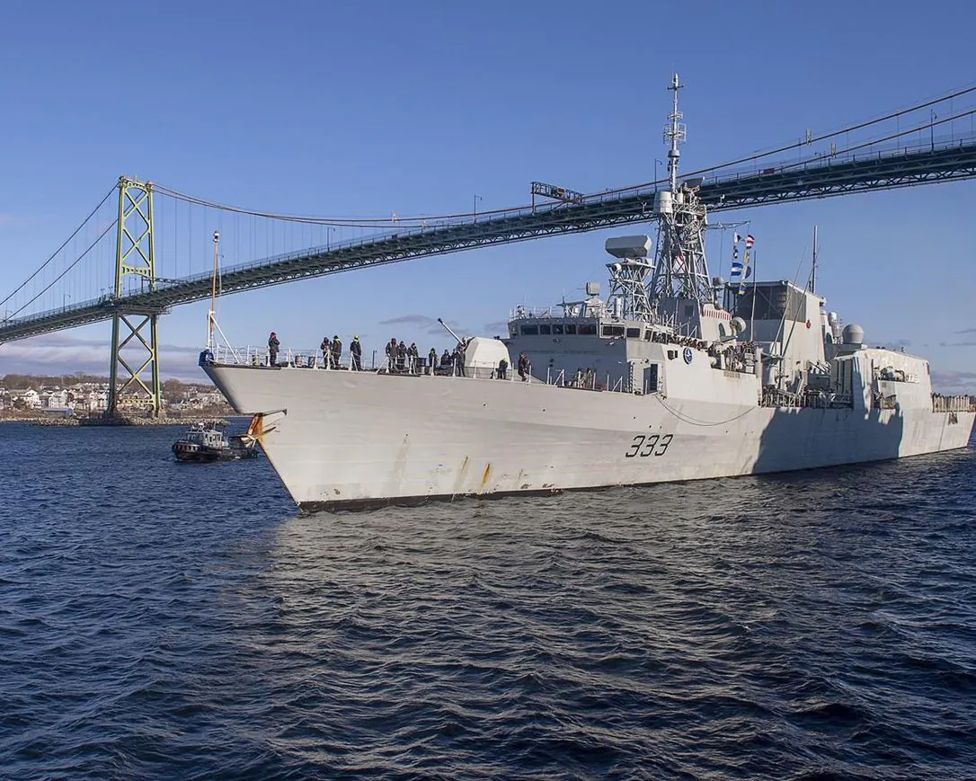 The Halifax-class frigate HMCS Toronto passes under the Angus L. Macdonald Bridge as it returns to Halifax on Dec. 23, 2020 after completing a six-month deployment in the Mediterranean Sea. (Andrew Vaughan/The Canadian Press)