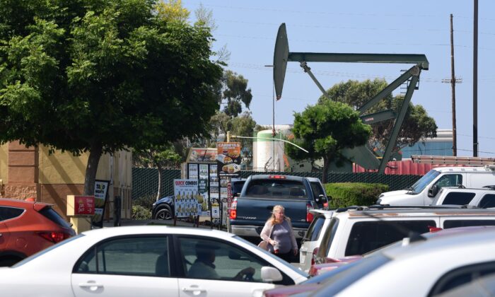 Motorists and pedestrians successful  a shipping plaza adjacent   an lipid  derrick pump successful  Signal Hill, California connected  September 25, 2019. (FREDERIC J. BROWN/AFP via Getty Images)