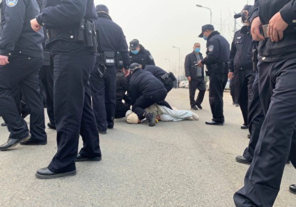 A female protester experiences overuse of force, with her neck pressured by the leg and knee of a policeman. Provided by an insider to The Epoch Times.
