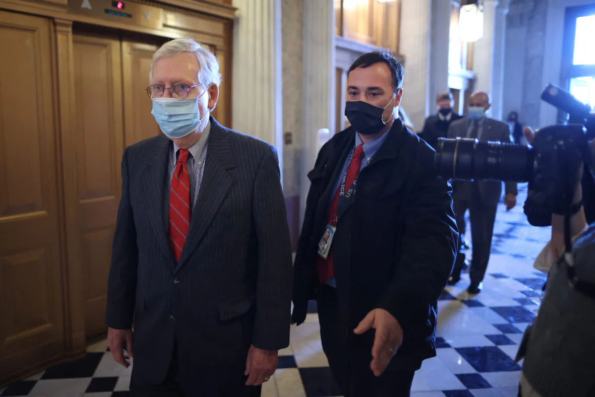 Senate Minority Leader Mitch McConnell (R-Ky.) (L) heads to the Senate Chamber at the U.S. Capitol in Washington on Jan. 28, 2021. (Chip Somodevilla/Getty Images)
