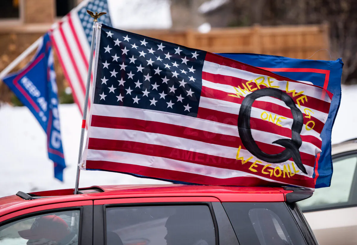 A car with a flag endorsing the QAnon drives by as supporters of President Donald Trump gather for a rally outside the Governor's Mansion on November 14, 2020 in St Paul, Minnesota. (Stephen Maturen/Getty Images)
