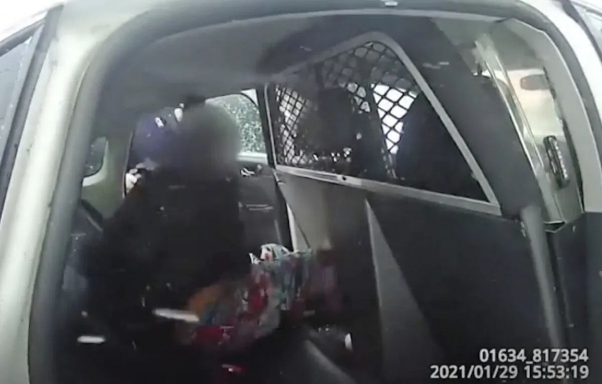 A still frame from a Rochester Police Department body-camera video shows a handcuffed 9-year-old girl in police custody in a police cruiser after police used pepper spray on her as she screamed for her father, in Rochester, N.Y., on Jan. 29. 2021. (Rochester Police Department via AP)