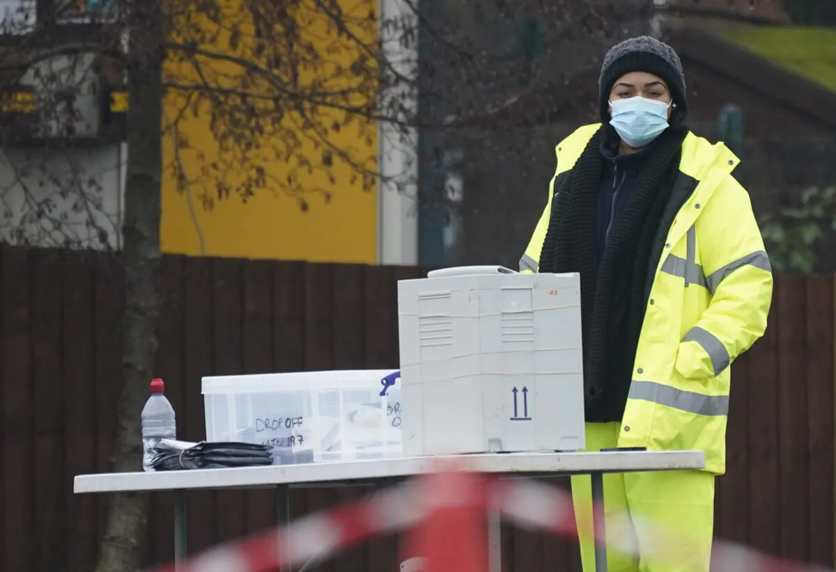 People hand in tests at a drive-in testing station as local authorities prepare to deploy COVID-19 testing in an effort to track down a South African CCP virus variant found in the area in Walsall, United Kingdom, Feb. 2, 2021. (Christopher Furlong/Getty Images)