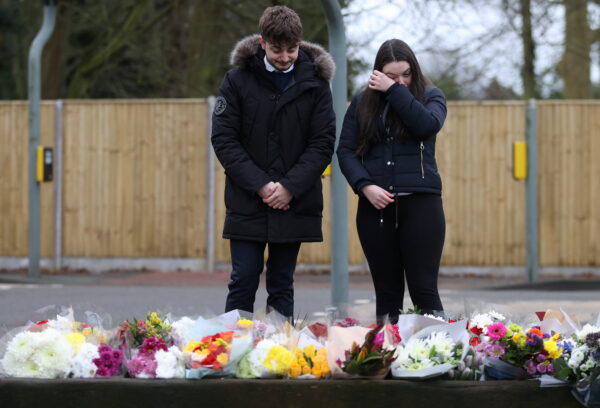 People look at flowers left near to the residence of Captain Sir Tom Moore