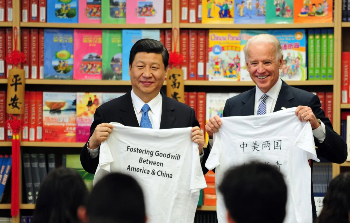 Then-U.S. Vice President Joe Biden and then-Chinese vice chair Xi Jinping display shirts with a message given to them by students at the International Studies Learning School in Southgate, outside Los Angeles, on Feb. 17, 2012. (FREDERIC J. BROWN/AFP via Getty Images)