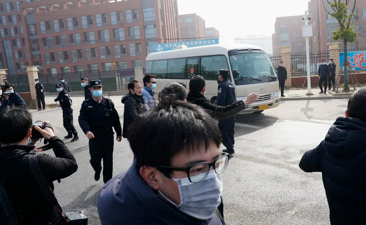 Journalists and security personnel gather near the entrance of the Wuhan Institute of Virology after a visit by the World Health Organization team in Wuhan in China's Hubei province, China, on Feb. 3, 2021. (Ng Han Guan/AP Photo)