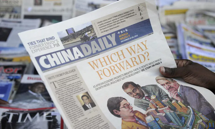 A newspaper consumer reads a copy of China's Africa edition of its daily newspaper infront of a news stand in the Kenyan capital in this Dec. 14, 2012, file photo. (Tony Karumba/AFP via Getty Images)